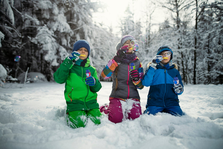 Children blowing non-toxic bubbles in the snow